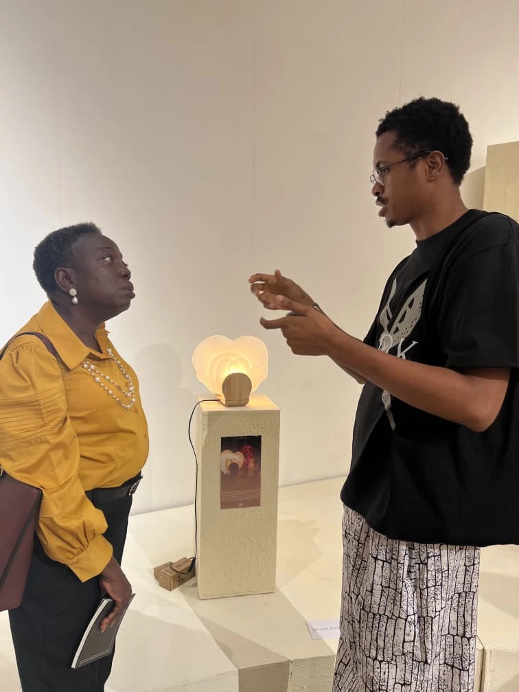 The designer speaking with a visitor beside Diba-Gele