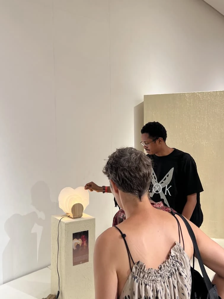 A visitor and the designer discussing Diba-Gele at Design Week Lagos