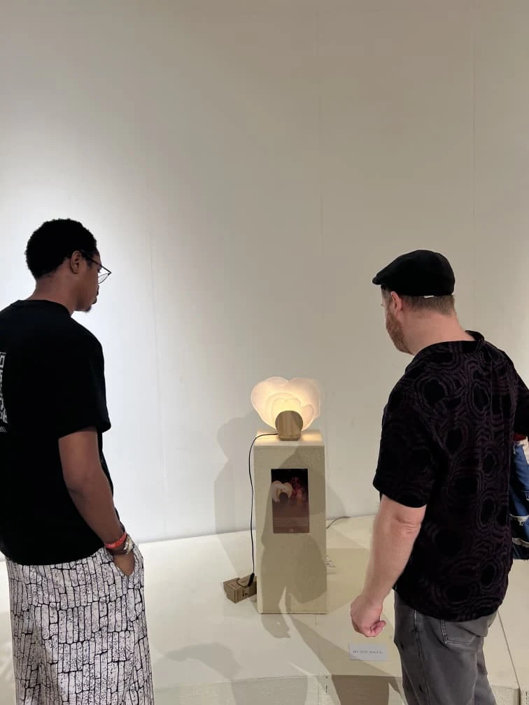 Visitors viewing Diba-Gele, a glowing sculptural table lamp, at Design Week Lagos